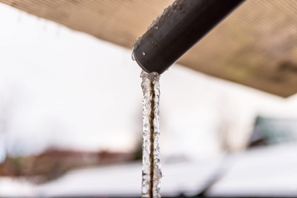 frozen water hanging from the roof through a pipe