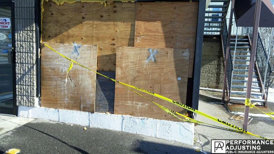 storefront wall boarded up after a collision