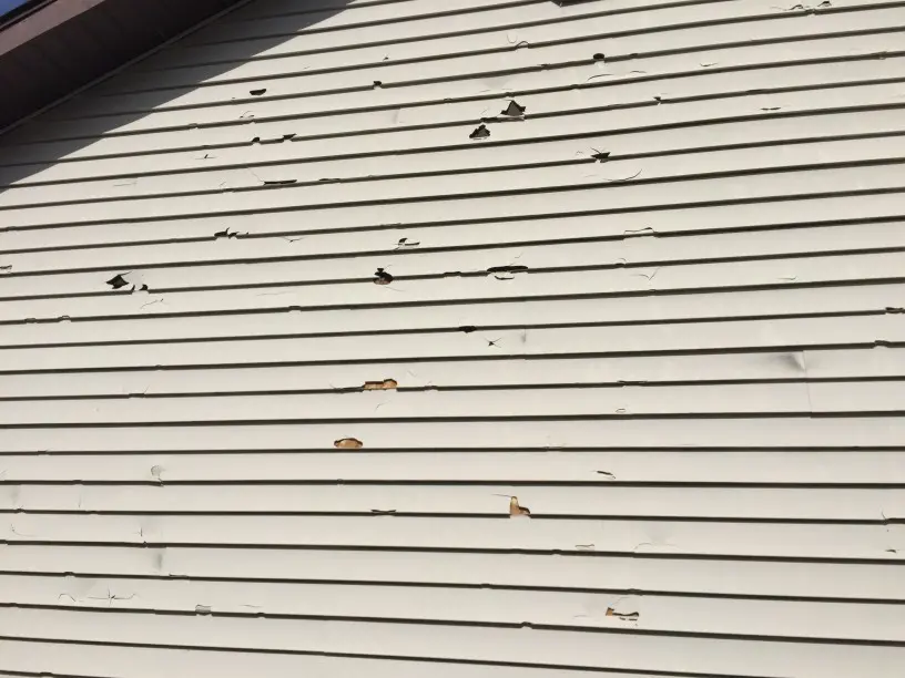 storm-caused-hail-damage-to-vinyl-siding-on-a-house_t20_Joa7yo check the exterior of your home for vinyl siding damage ri